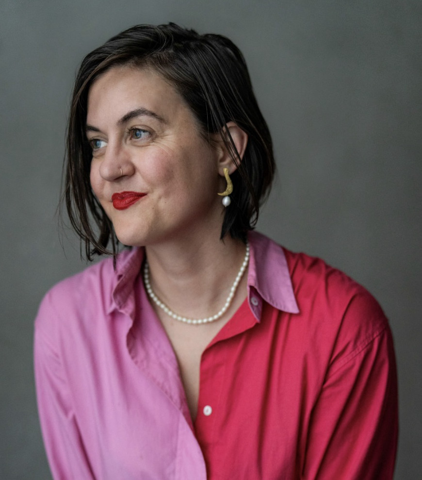 Rosalind Croad, in bright pink shirt, smiling toward the left